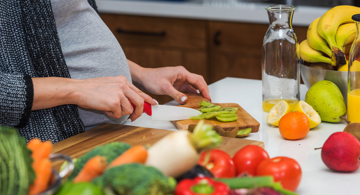Pregnant woman cutting fruit