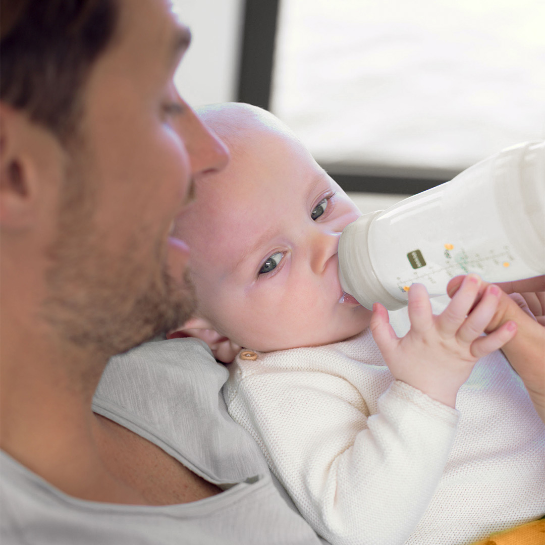 Banner baby drinking with father