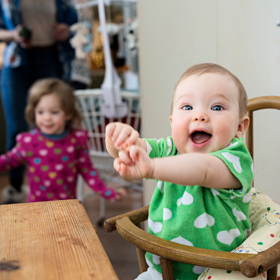 happy baby sitting at table
